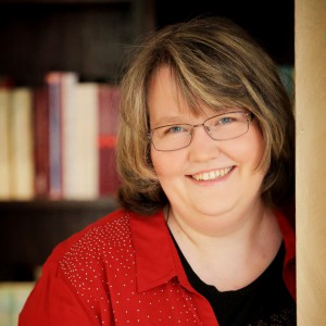 Portraitfoto von der Autorin Nicole Gozdek vor einem Bücherregal 